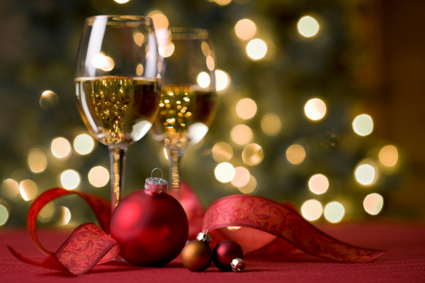 two glasses of wine in front of a Christmas tree